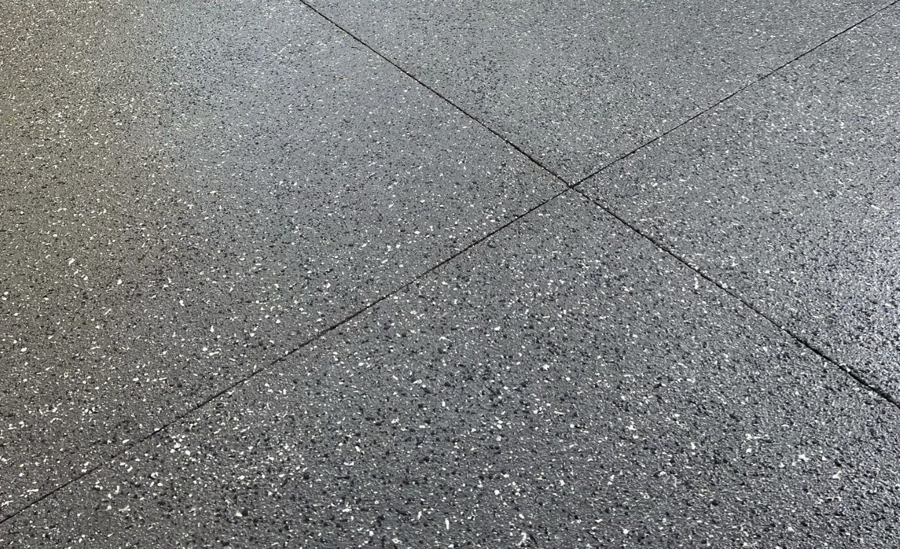 Close-up of speckled epoxy garage floor coating with control joints in Tacoma, WA